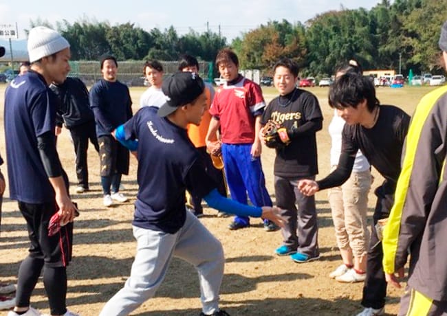 試合前にグラウンドでじゃんけんをする参加者たち。和やかな雰囲気