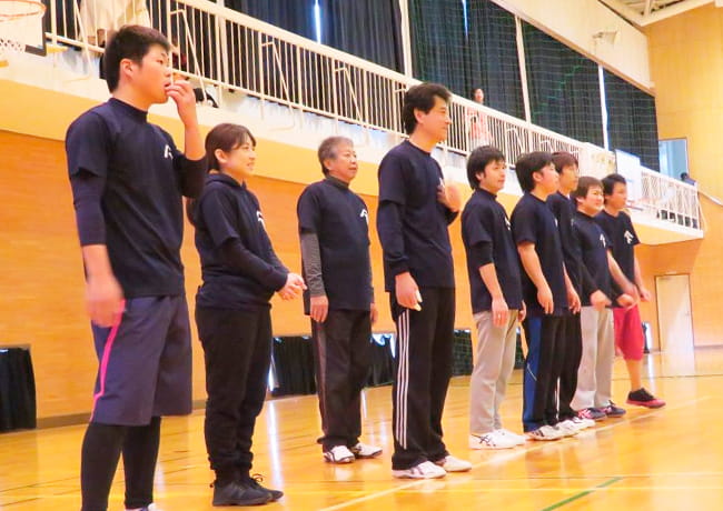 体育館で横一列に並ぶ参加者たち。試合開始前の整列の様子